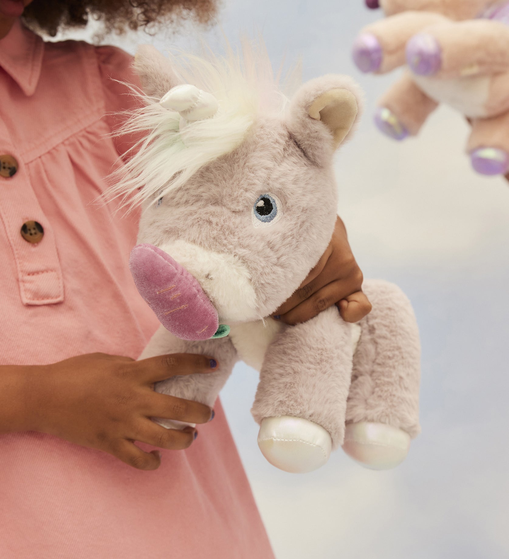 A child holding and feeding the toy unicorn