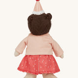 Rear view of the Olli Ella Dress Me Dinky - Sophie Sundae, a doll with brown hair and green eyes wearing a pink polka dot dress, light pink cardigan and a pink party hat. Cream background.