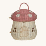 The Olli Ella Rattan Woven mushroom doll's house, with a pink spotty toadstool top and an opening door. 