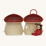The Olli Ella Rattan Woven mushroom doll's house, with a red spotty toadstool top. It is opened all the way, and inside is a dozy dinkum doll resting. 