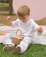 A child holding the Olli Ella Rattan Berry Basket with Lining – Gumdrop