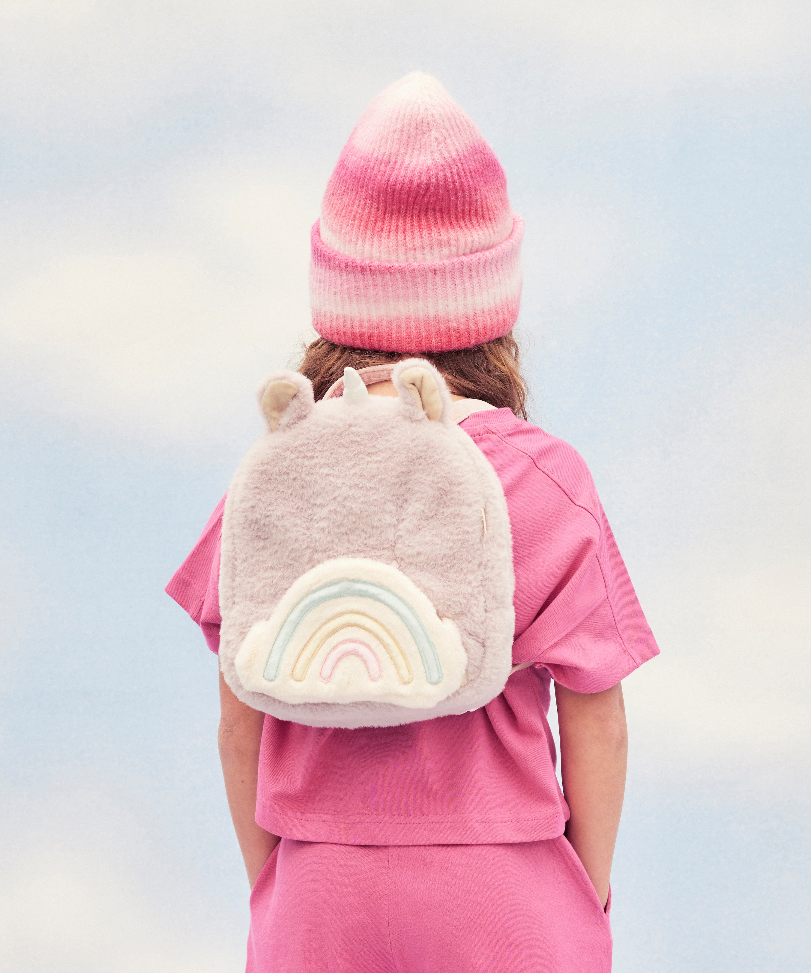 A child wearing the pink fluffy Olli Ella backpack.
