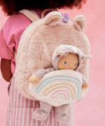 A close up of the pink fluffy backpack with a dinky dinkum doll sitting inside the bag
