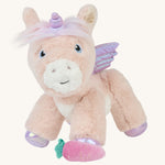 The Olli Ella Shimmer unicorn, which has light pink fur and a lilac mane, with a pink carrot at its feet