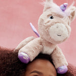 The toy unicorn is balancing on a little girl's head