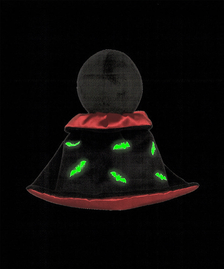 A view of the back of the Olli Ella Vincent Vampire Dinky Dinkum doll. A soft vampire doll with a black cape with bat shaped glow in the dark details on the back. These soft toys are part of Olli Ella's Halloween collection available here at Babipur.