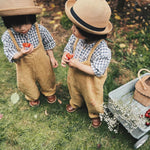 Girl sat down on a blue blanket eating a cake next to the Olli Ella vintage blue wonder wagon