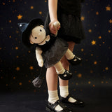 A child carrying the Olli Ella Wendy Witch dream Dinkum doll by their hand. A dinkum doll with a black dress, witches hat, black shoes and a magnetic broom accessory. This doll is part of Olli Ella's Halloween collection available here at Babipur.