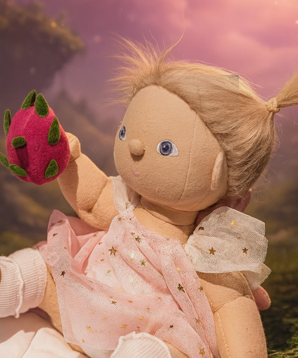 Olli Ella Willow dinkum doll holding the dragon fruit from the Olli Ella fairy food set.