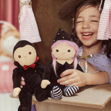 A child playing with a Vincent vampire and a Willa Witch dinky dinkum doll.  These soft toys are part of Olli Ella's Halloween collection available here at Babipur.