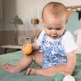 A child sat on a green bed sheet
