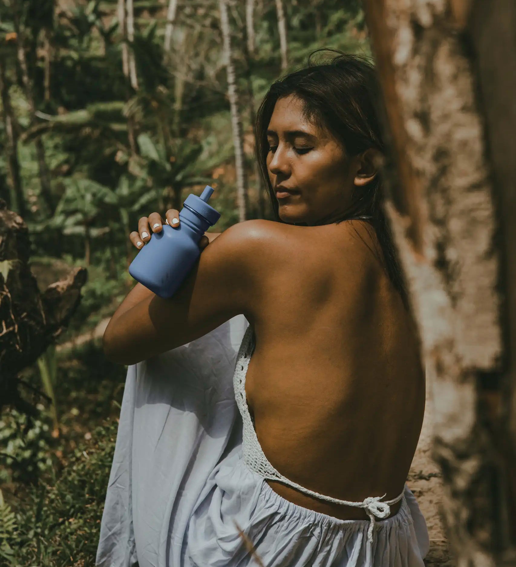 Woman holding a 350ml swipe right blue One Green Bottle stainless steel water bottle