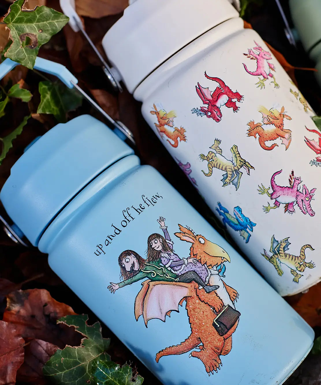 A blue and cream One Green Bottle stainless steel bottles on a pile of autumn leaves showing different Zog character designs