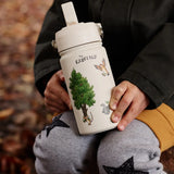 Child sitting on a tree stump and holding a stainless steel cream One Green bottle water bottle with a Gruffalo characters