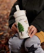 Child sitting on a tree stump and holding a stainless steel cream One Green bottle water bottle with a Gruffalo characters