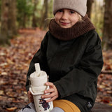 Child sitting on a tree stump and holding a One Green bottle stainless steel water bottle in cream with a Gruffalo characters