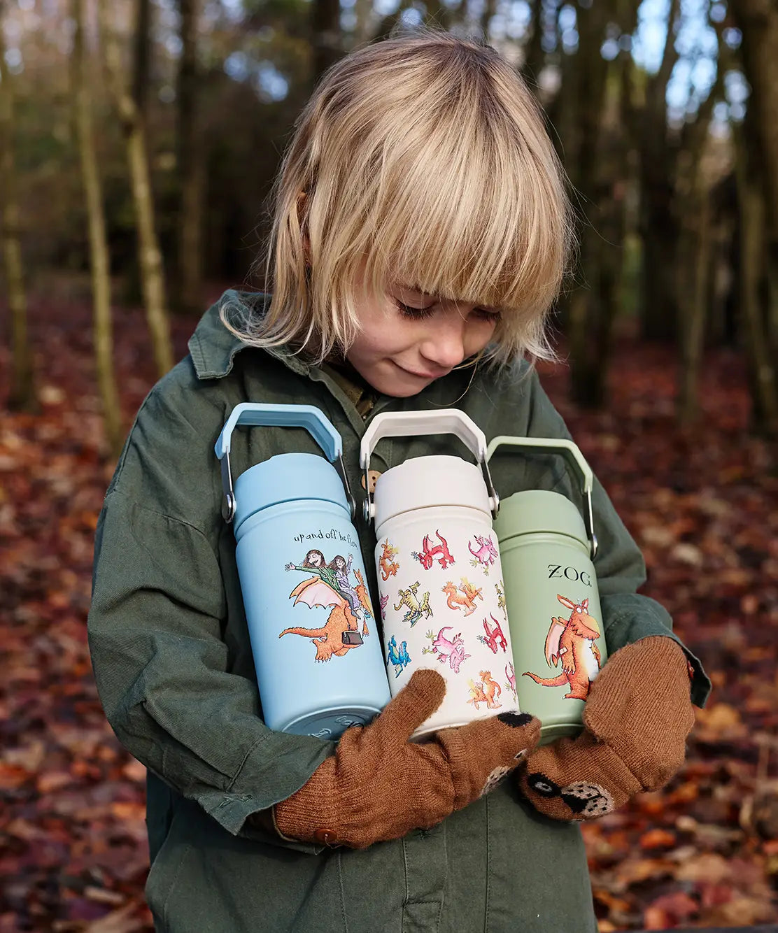 Child holding All 3 One Green Bottle collection bottles in the forest showing the different characters