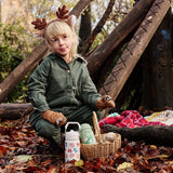 Child sitting next to a cream and green  One Green Bottle Zog collection bottles in the forest 
