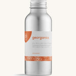A bottle of the Georganics orange oil pulling mouthwash on a cream background