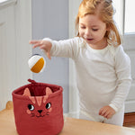 A child putting a Roommate Canvas Ball into the mini cat basket