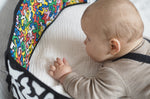 A child look at the 'Baby' print on the Etta Loves X Keith Haring Reversible Baby Sensory Strip