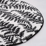 A baby looking and enjoying and looking at the black and white Fern side of the Etta Loves Reversible Organic Cotton Baby Play Mat - Plant Print 