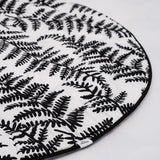 A baby looking and enjoying and looking at the black and white Fern side of the Etta Loves Reversible Organic Cotton Baby Play Mat - Plant Print 