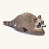 A small wooden Ostheimer racoon figure on a cream background.