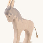 A grey wooden standing Ostheimer figure on a cream background.
