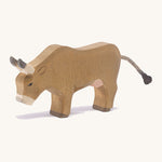 A wooden OStheimer alp cow eating on a cream background.