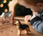 A child playing with an Ostheimer German shepherd dog wooden toy figure. These wooden figures are part of a wide range of expertly hand crafted wooden toys here at Babipur. 