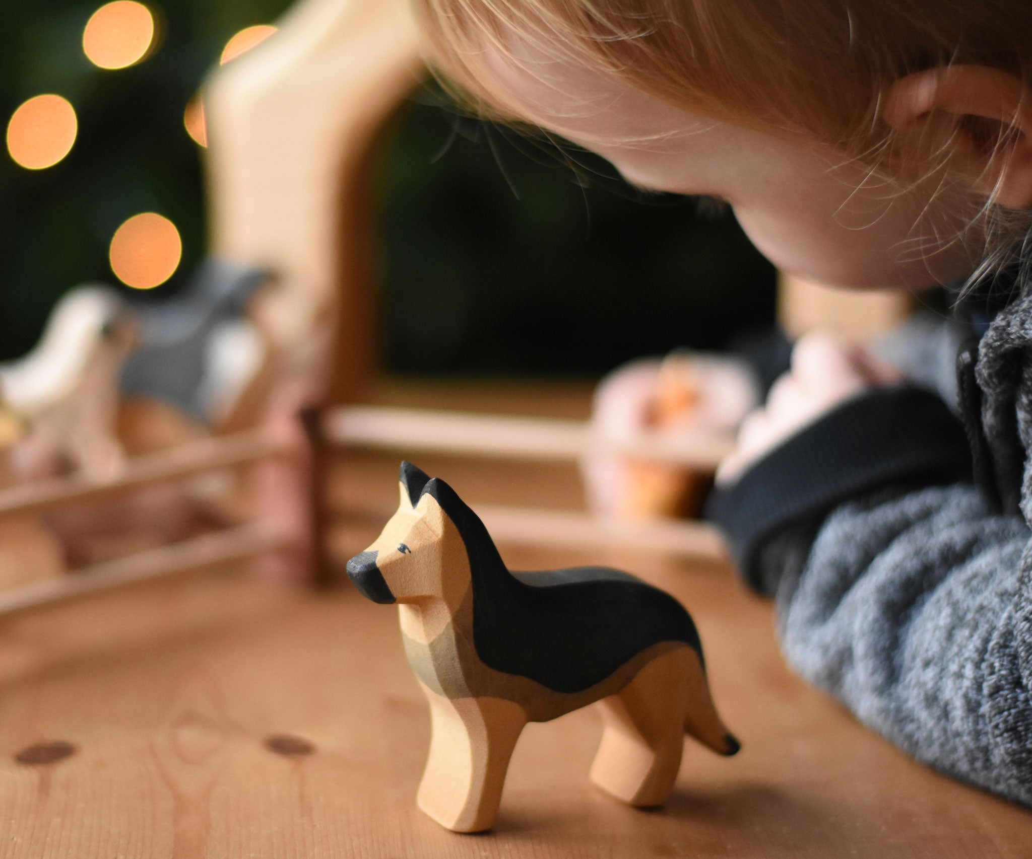 A child playing with an Ostheimer German shepherd dog wooden toy figure. These wooden figures are part of a wide range of expertly hand crafted wooden toys here at Babipur. 