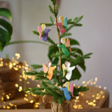Ostheimer angel wooden toy decorations placed on a small Christmas tree. 