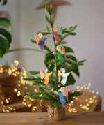 Ostheimer angel wooden toy decorations placed on a small Christmas tree. 