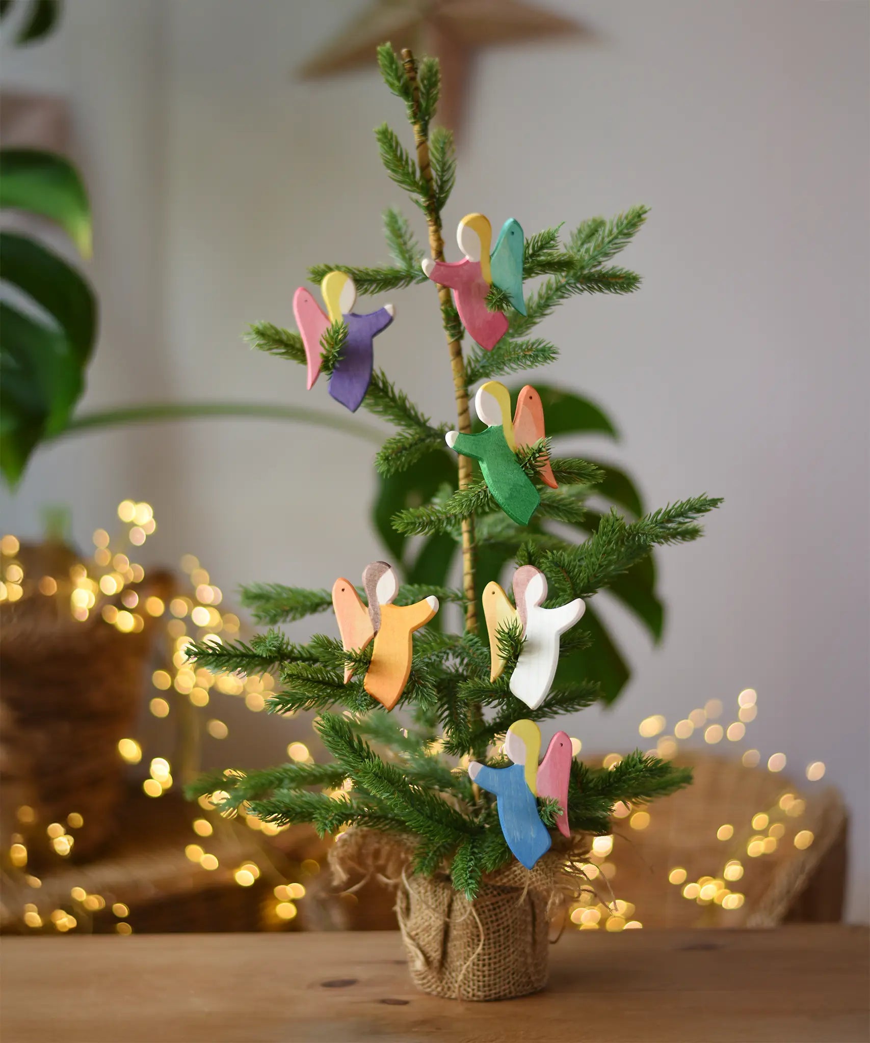 Ostheimer angel wooden toy decorations placed on a small Christmas tree. 