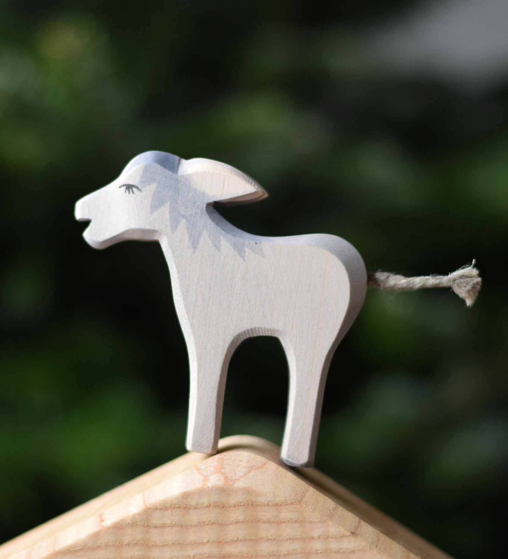 An Ostheimer angry wooden toy figure placed on the house shaped piece from the Ostheimer 4 piece house set. Ostheimer's range of hand crafted, heirloom quality wooden toys are available to buy at Babipur. 