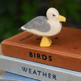 A close up of an Ostheimer seagull placed on a pile of books.