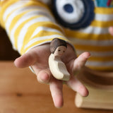 Ostherimer baby wooden toy figure in a child's hand. 