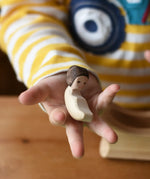 Ostherimer baby wooden toy figure in a child's hand. 