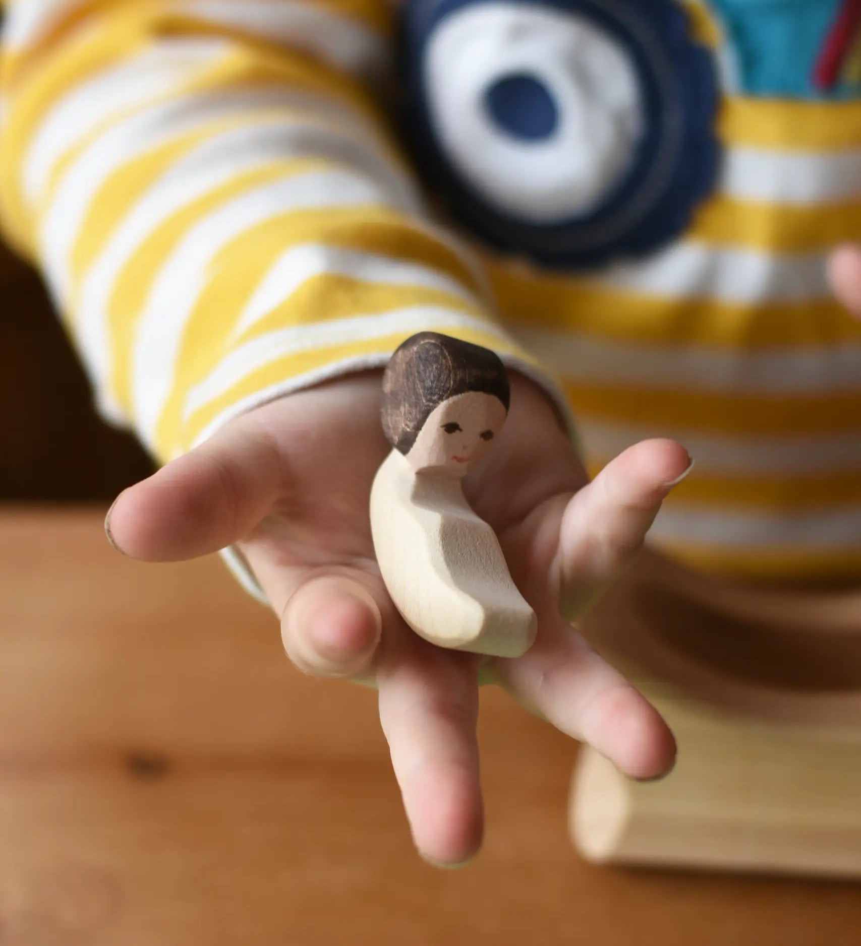 Ostherimer baby wooden toy figure in a child's hand. 