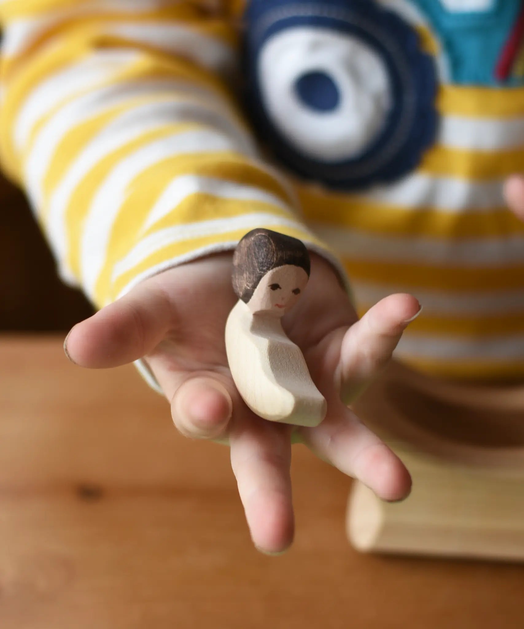 Ostherimer baby wooden toy figure in a child's hand. 