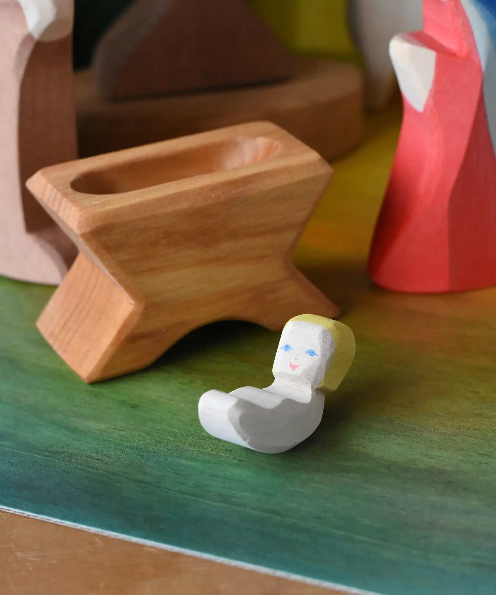 Ostheimer baby jesus and crib wooden toy nativity figure in a small world play scene. 