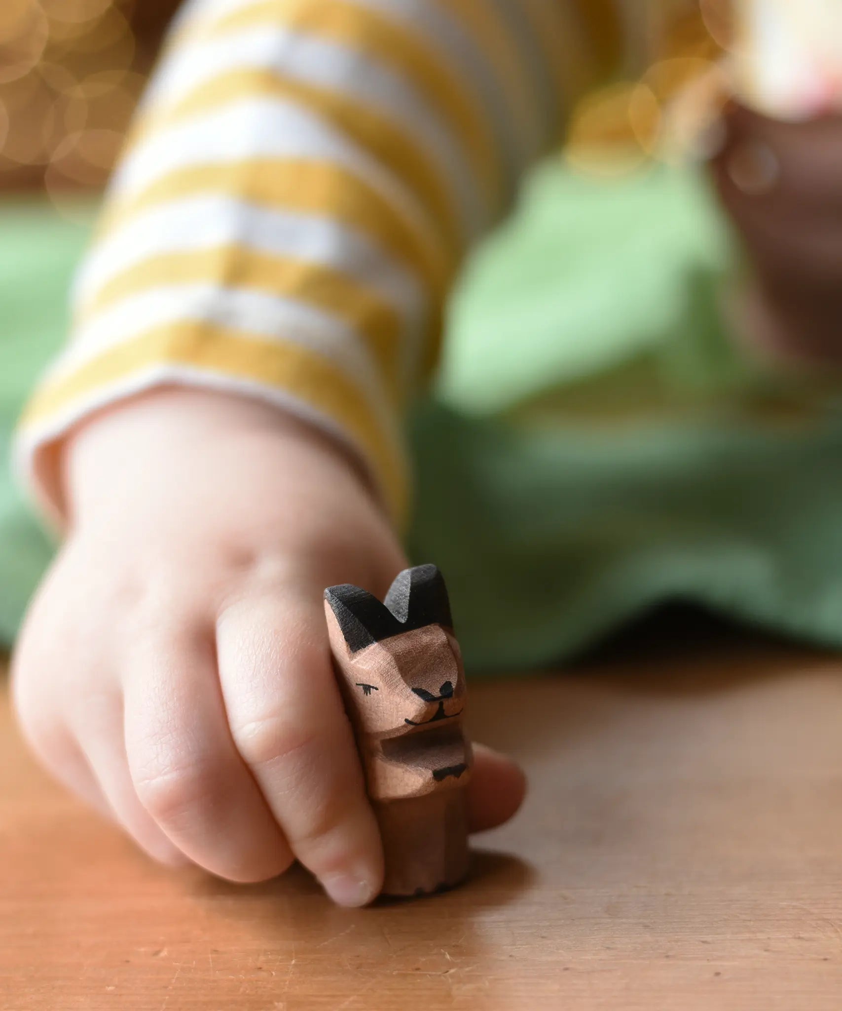 Ostheimer baby kangaroo handmade wooden toy figure in a child's hand.