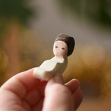 Ostherimer baby wooden toy figure in an adult's hand. 
