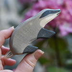 An Ostheimer badger figure with straight head shown in an adult's hand for scale.