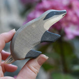 An Ostheimer badger figure with straight head shown in an adult's hand for scale.
