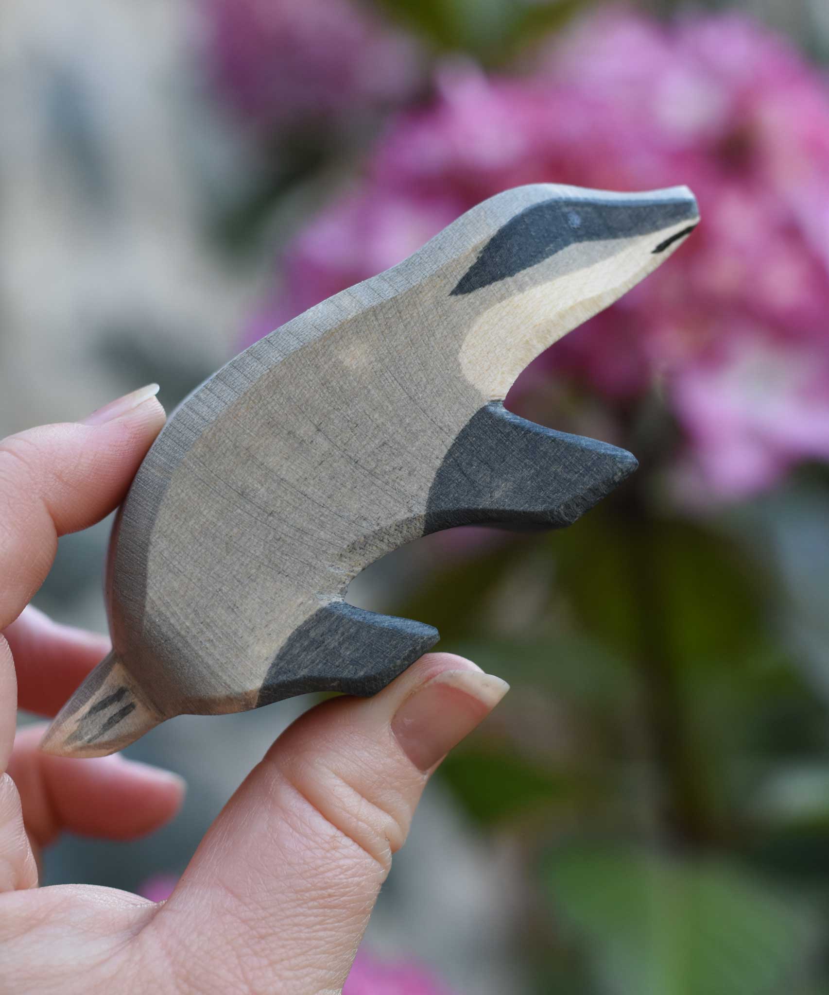 An Ostheimer badger figure with straight head shown in an adult's hand for scale.