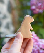 An Ostheimer sitting beaver wooden toy figure in an adult's hand to show scale. Check out our full range of expertly crafted wooden toy figures and scenery here at Babipur.