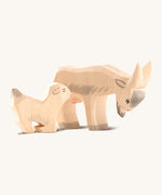 Ostheiemer handmade and hand painted goat kid wooden figure next to the drinking Billy goat figure.