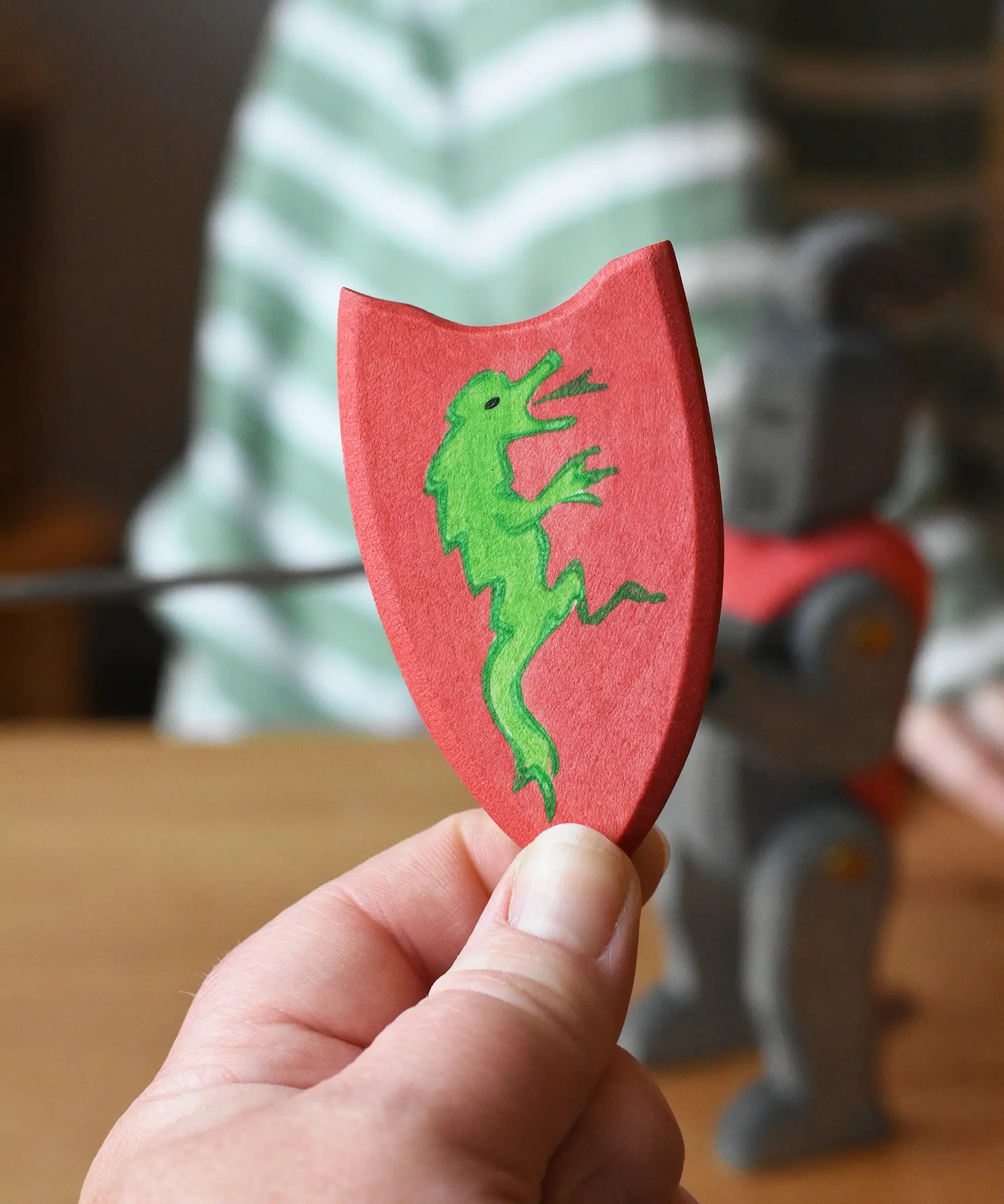 Red Ostheimer black knight shield with green dragon in an adult's hand. 